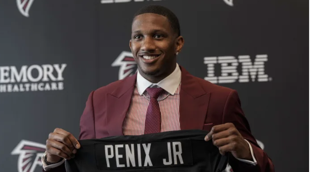 Michael Penix Jr. Holding his jersey in his first conference in Atlanta, Forbes.
